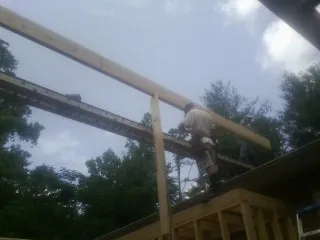 Carpenter setting a ridge beam over a new addition frame — Ice Dam Removal by Roofing Brothers in Chalfont