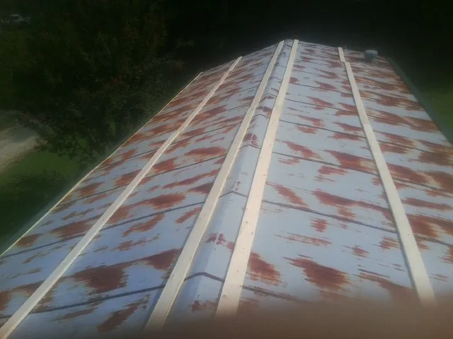 Rusted metal roof panels with new wood purlins before replacement — Storm Damage Roof Repair in Chalfont by Roofing Brothers
