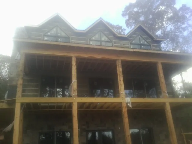 Dormers and porch framing on a large log home under construction — Roof Coating work by our crew in Chalfont