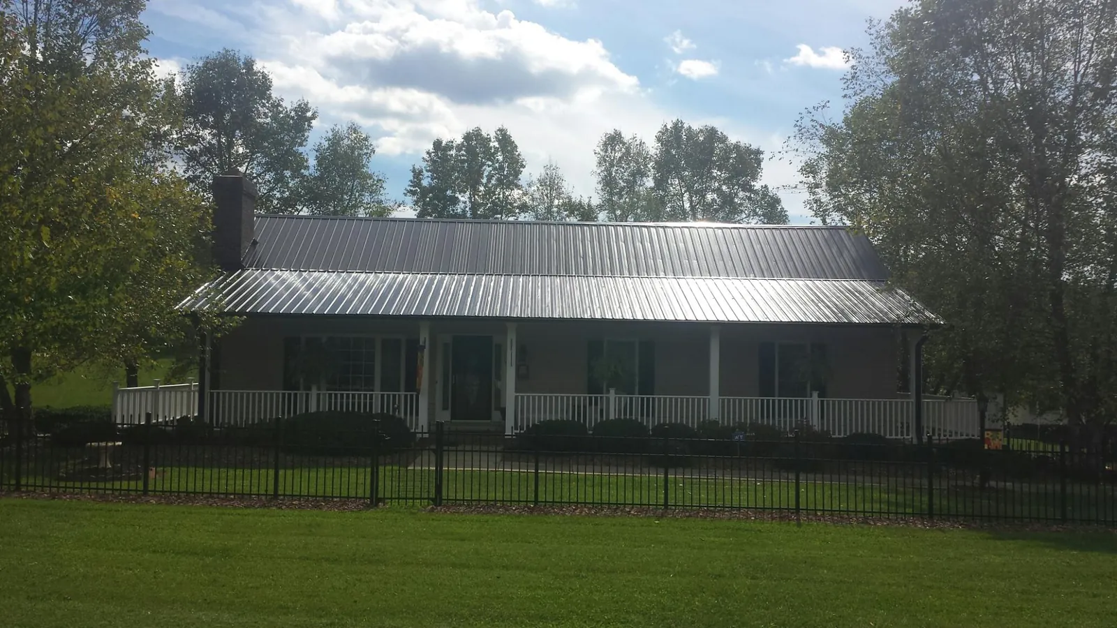 Gray metal roof on a brick ranch with a full width front porch — Gutter Guard Installation work by our crew in Chalfont