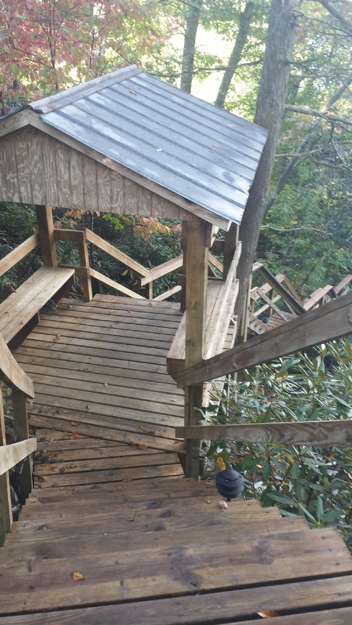Metal roofed shelter over wooden steps on a wooded walkway — Skylight Repair & Installation work by our crew in Chalfont