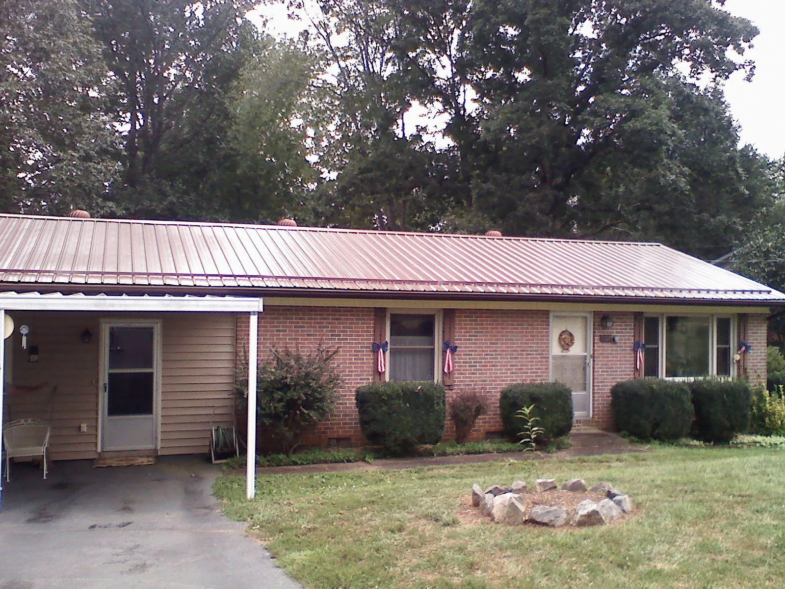 Bronze metal roof and carport on a brick ranch home — Roof Repair work by our crew in Chalfont